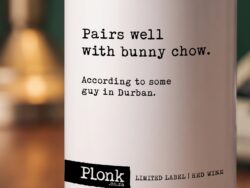 Bottle of Plonk wine showing the pairs well with bunny chow label